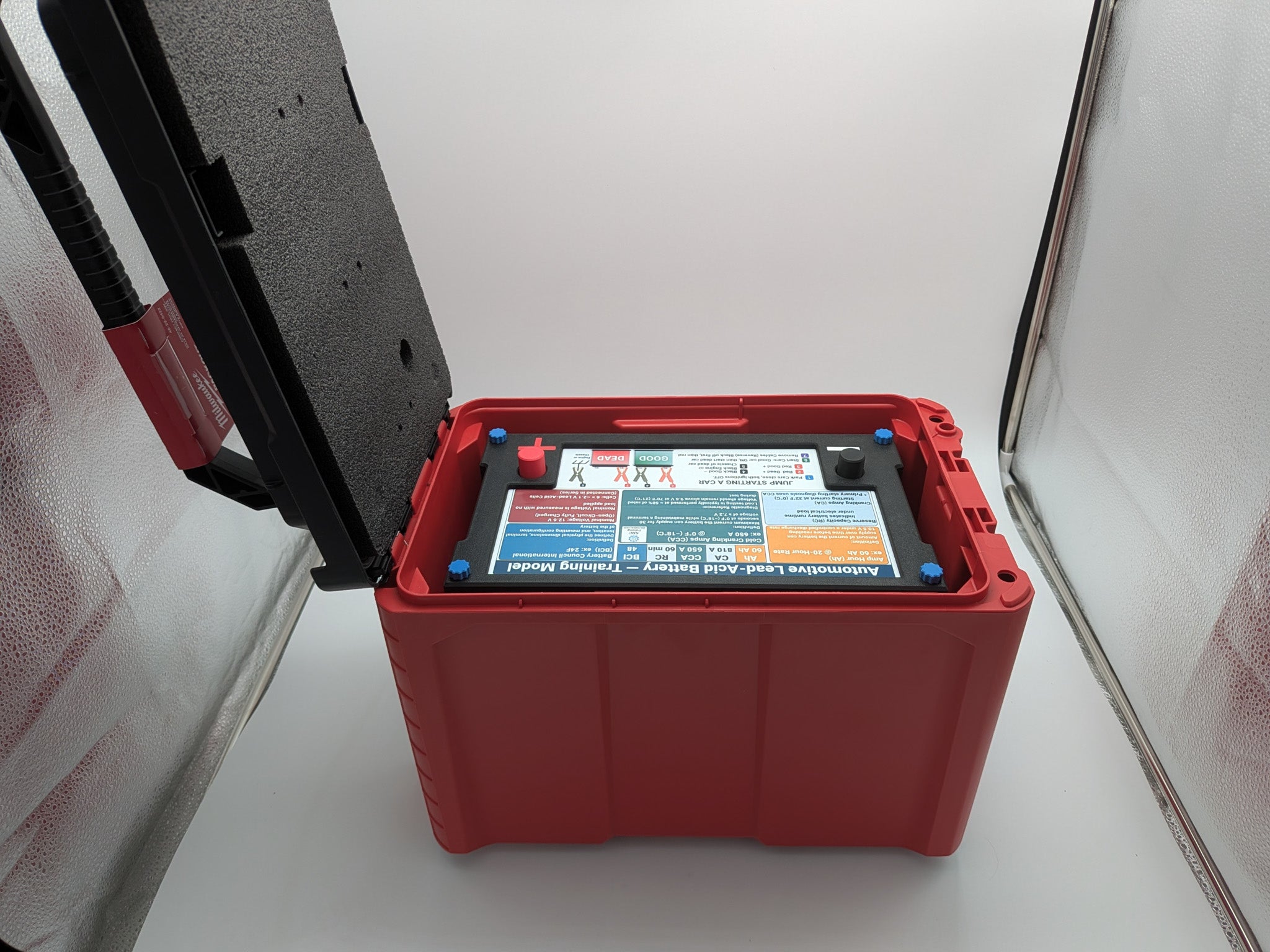 Battery training model inside Milwaukee PACKOUT carrying case with lid open